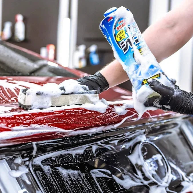 Aplicación de Shampoo Neutro Creamy Soft99 sobre carrocería de automóvil con guante de lavado.